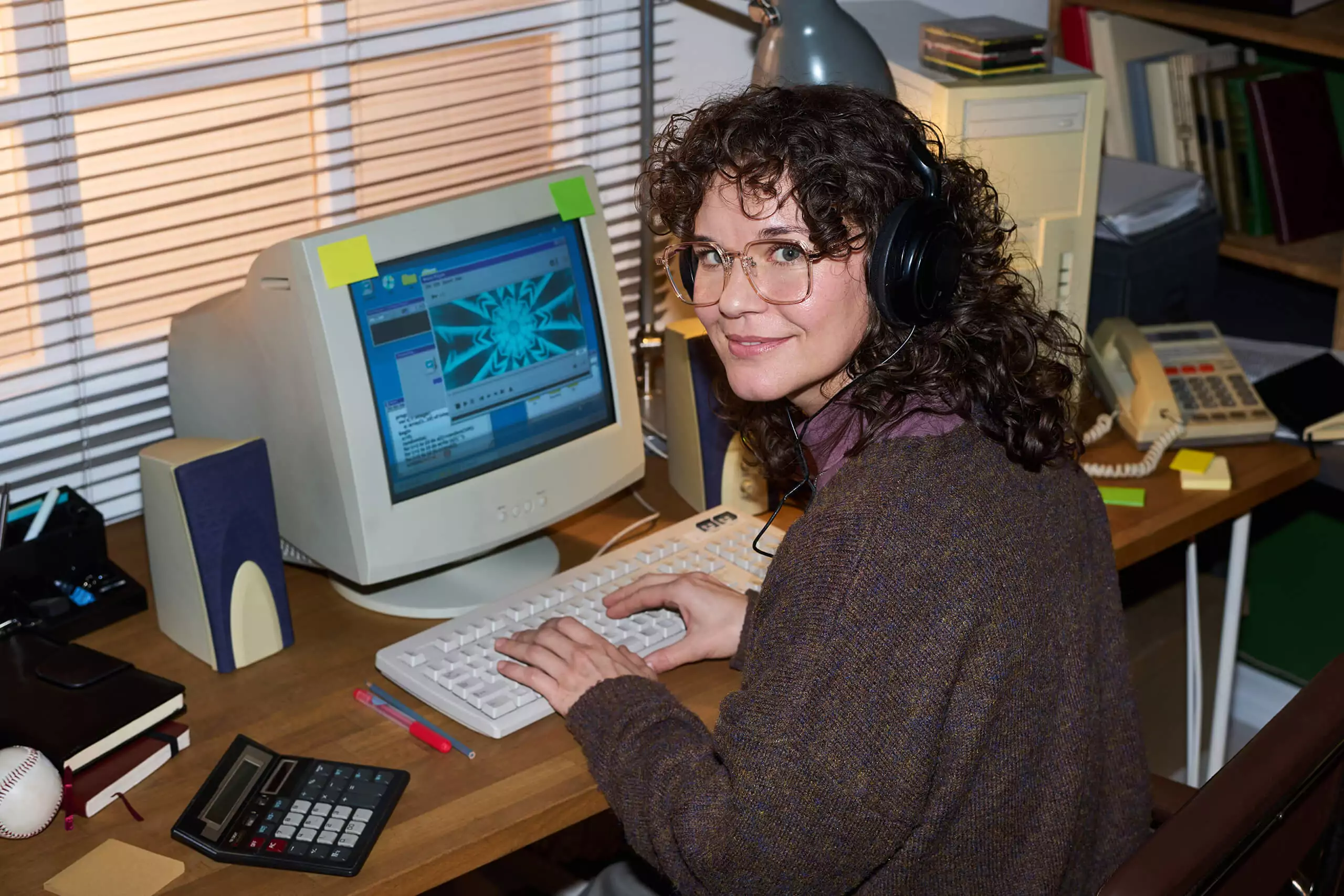 Femme années 90 avec lunettes sur son vieil ordinateur